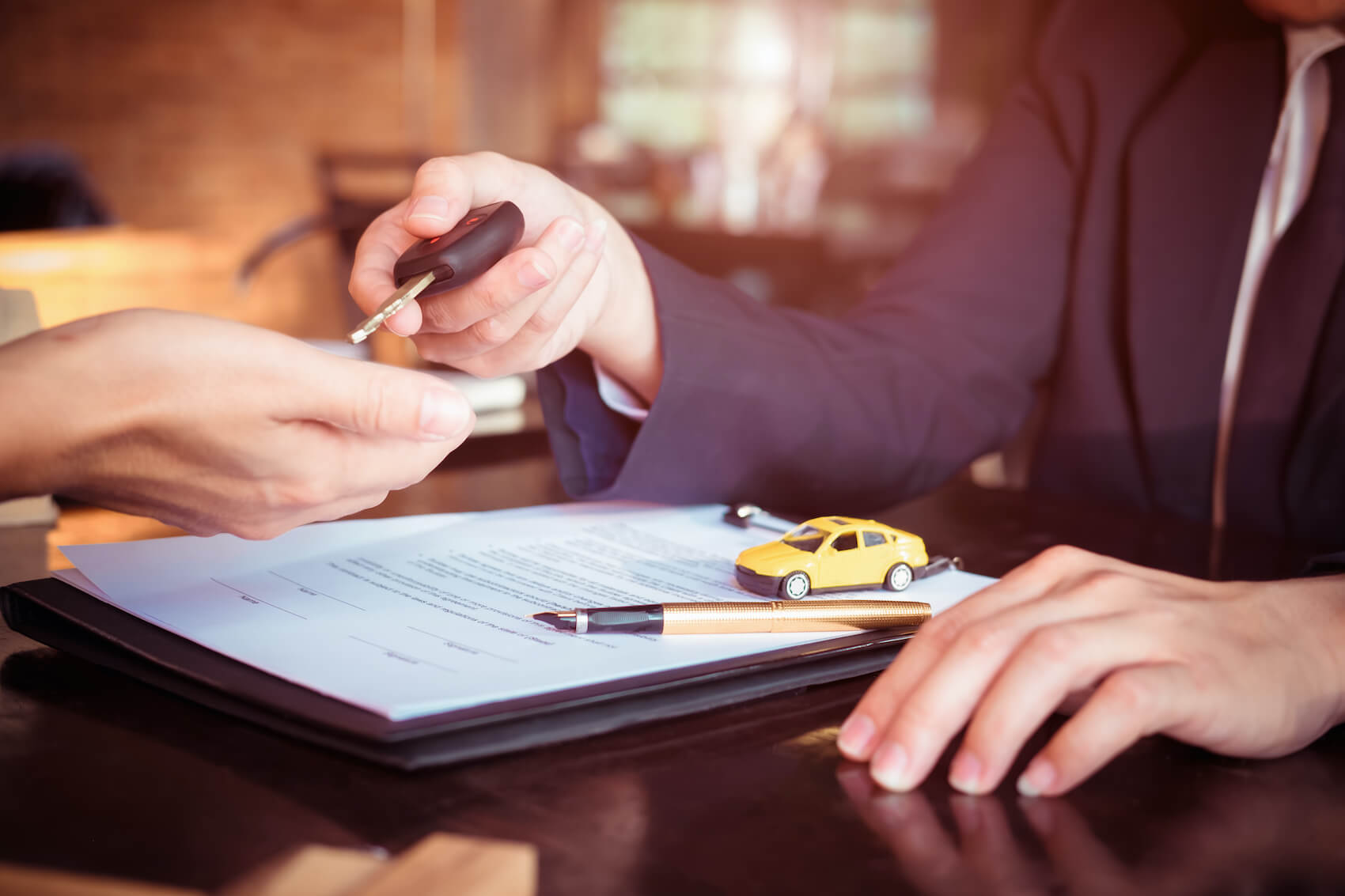 Sales person handing keys to customers