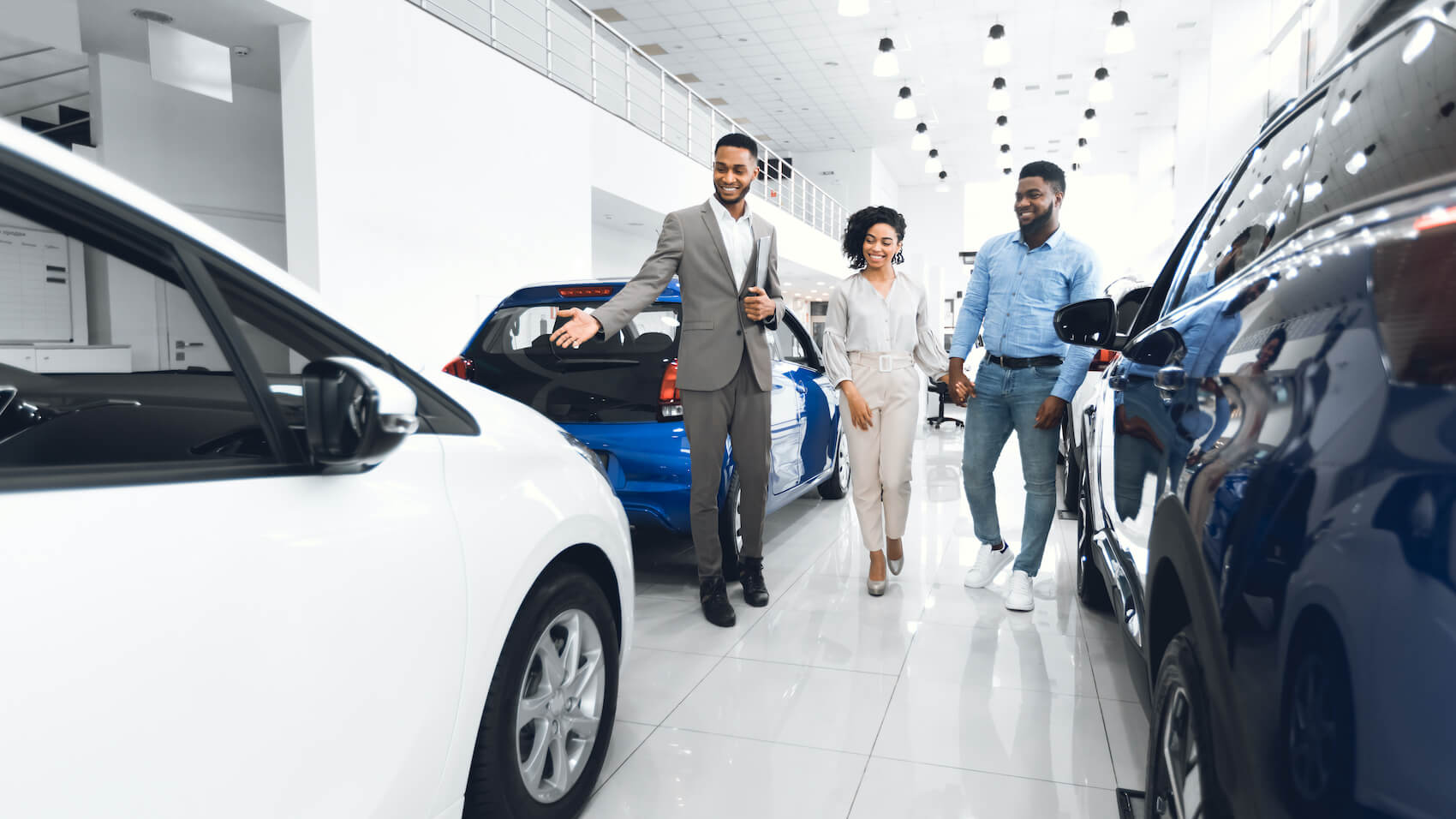 Husband And Wife looking at Cars with Sales Man
